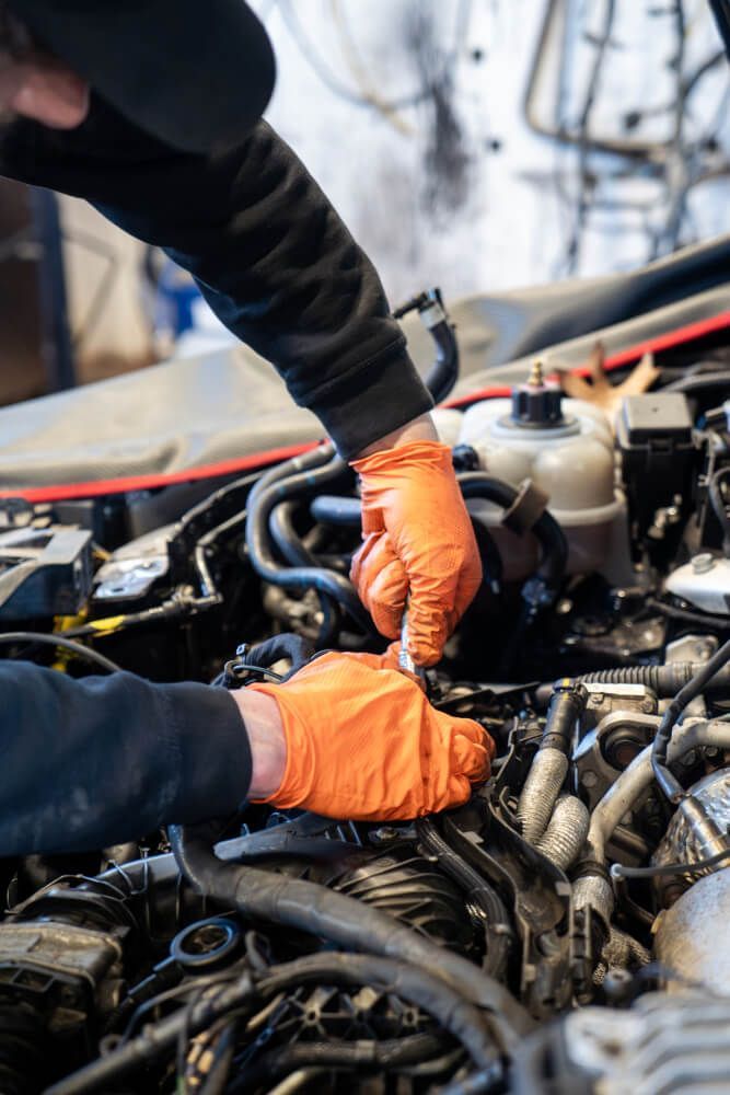 mechanic working in the engine bay of car