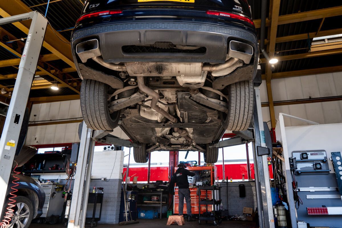 car up on stand with exhaust showing
