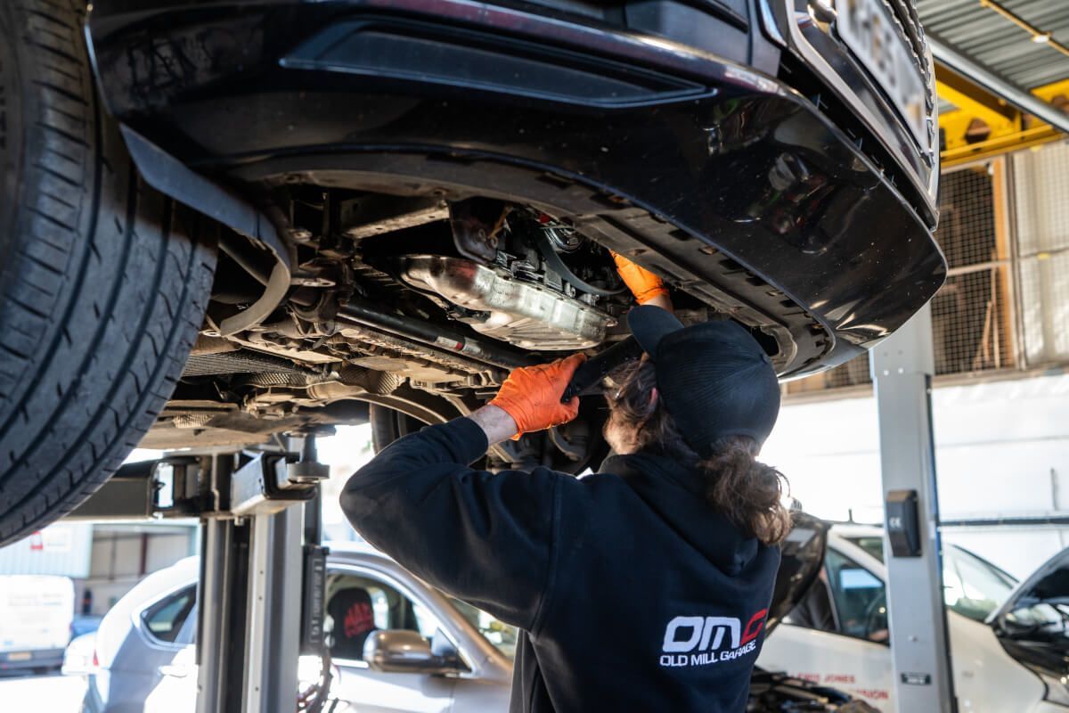 Mechanic under car with light