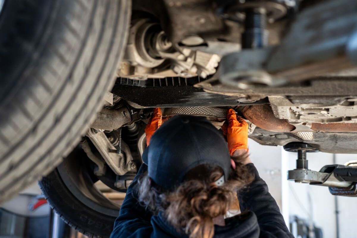 mechanic checking suspension under car