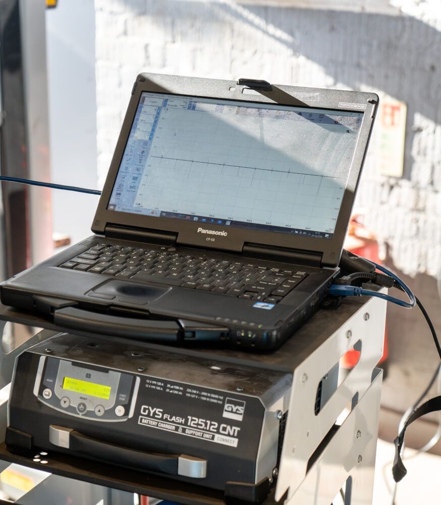 laptop plugged into a car for diagnostics