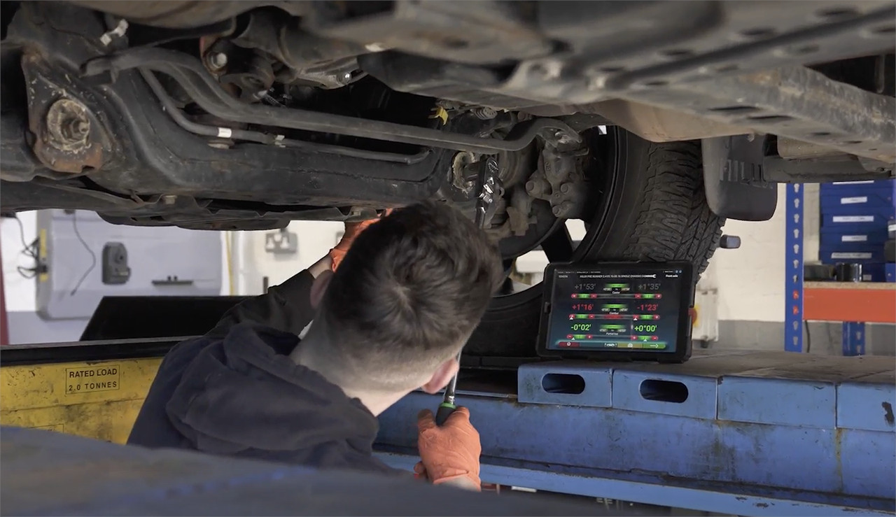 mechanic adjusting wheel alignment